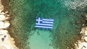 Η Γαλανόλευκη κυματίζει περήφανα στη θάλασσα του Πειραιά και στο Δημοτικό θέατρο της πόλης